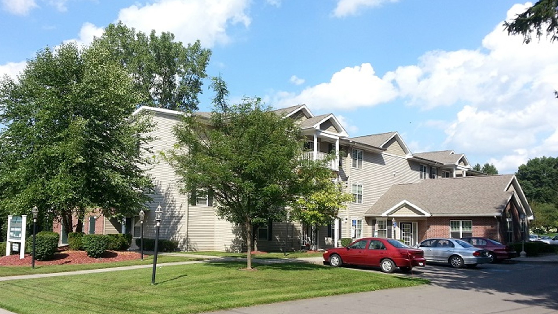 Senior Apartments near Homer NY image of ellis pines apartments side view with parking from two plus four property management