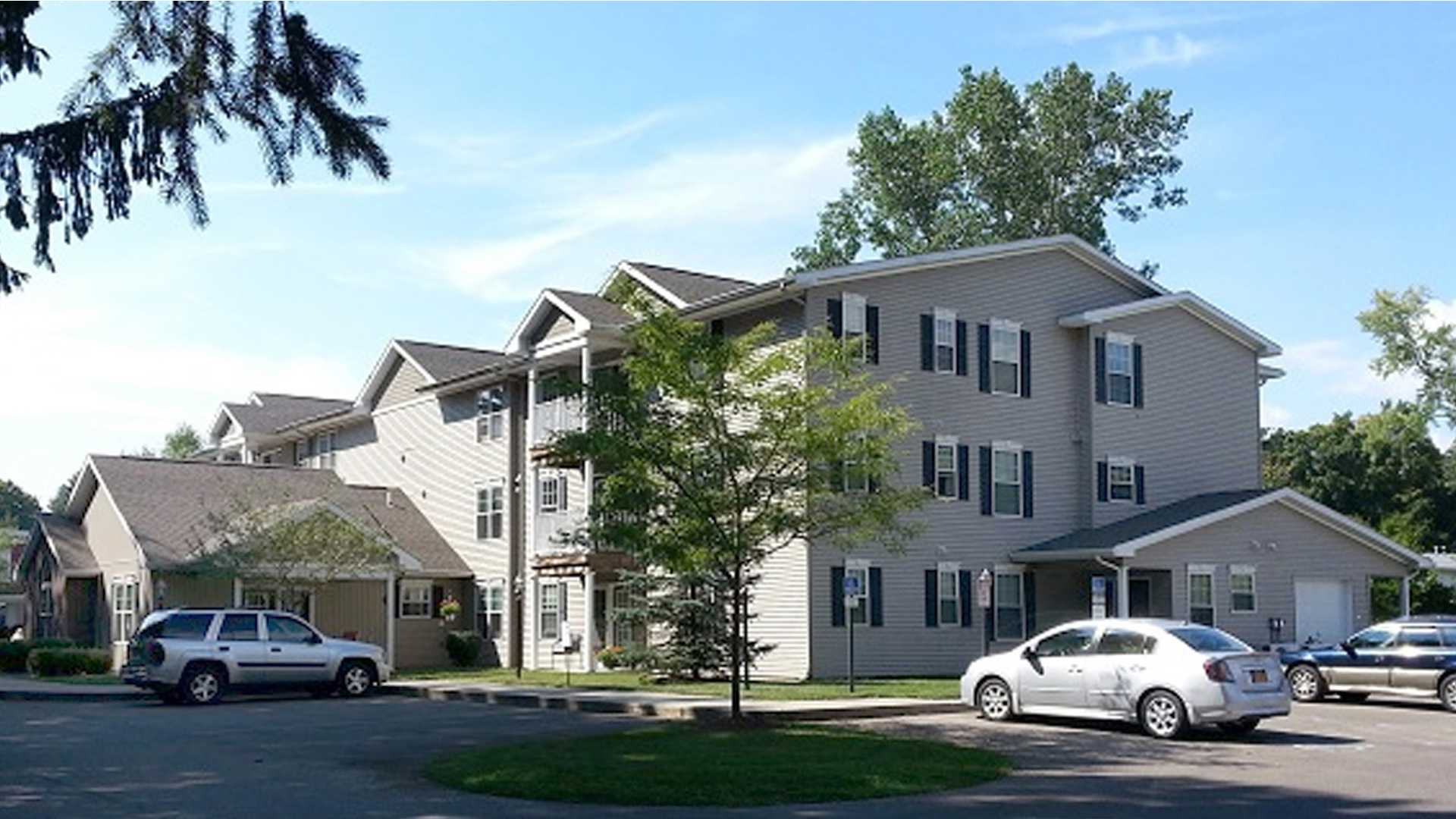 Senior Apartments near Homer NY image of ellis pines apartments front view with parking from two plus four property management