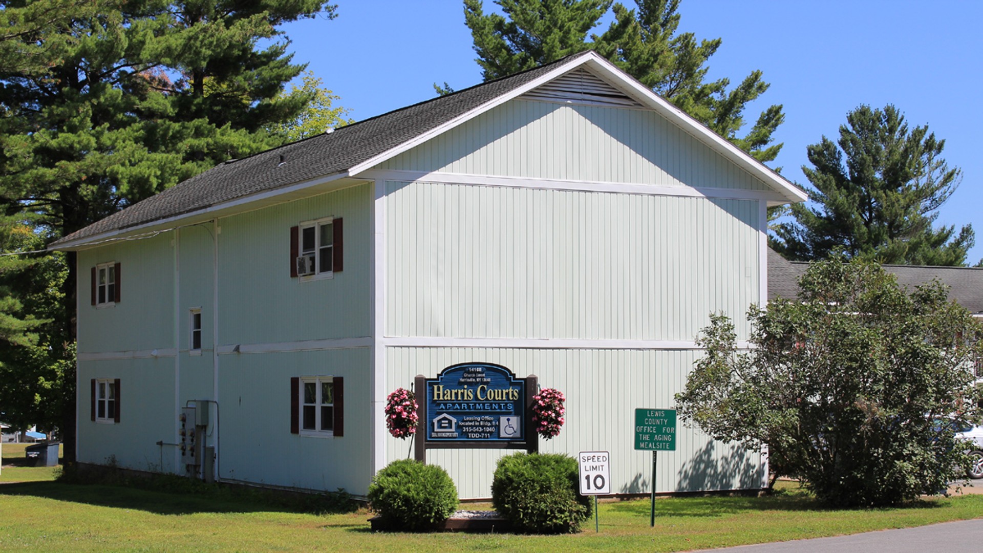 Senior Apartments near Harrisville NY image of harris court apartment sign equal housing opportunity 315-543-1040 tdd 711 leasing office from two plus four management