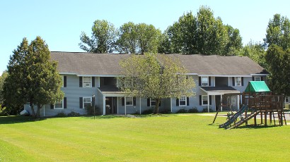 Apartments near Sackets Harbor NY exterior thumbnail image of shipyard family apartments with playground for two plus four management