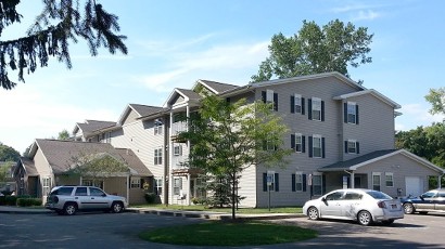 Senior Apartments near Homer NY thumbnail image of ellis pines apartments front view with parking from two plus four property management