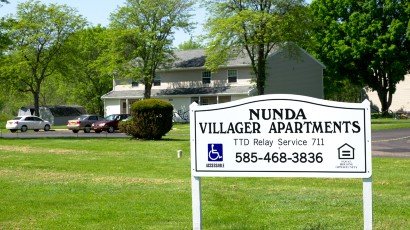 Apartments near Nunda NY thumbnail image of exterior view of the Nunda Villager apartments with sign that reads ttd relay service 711 accessible and equal housing opportunity call 585-468-3836 for two plus four management