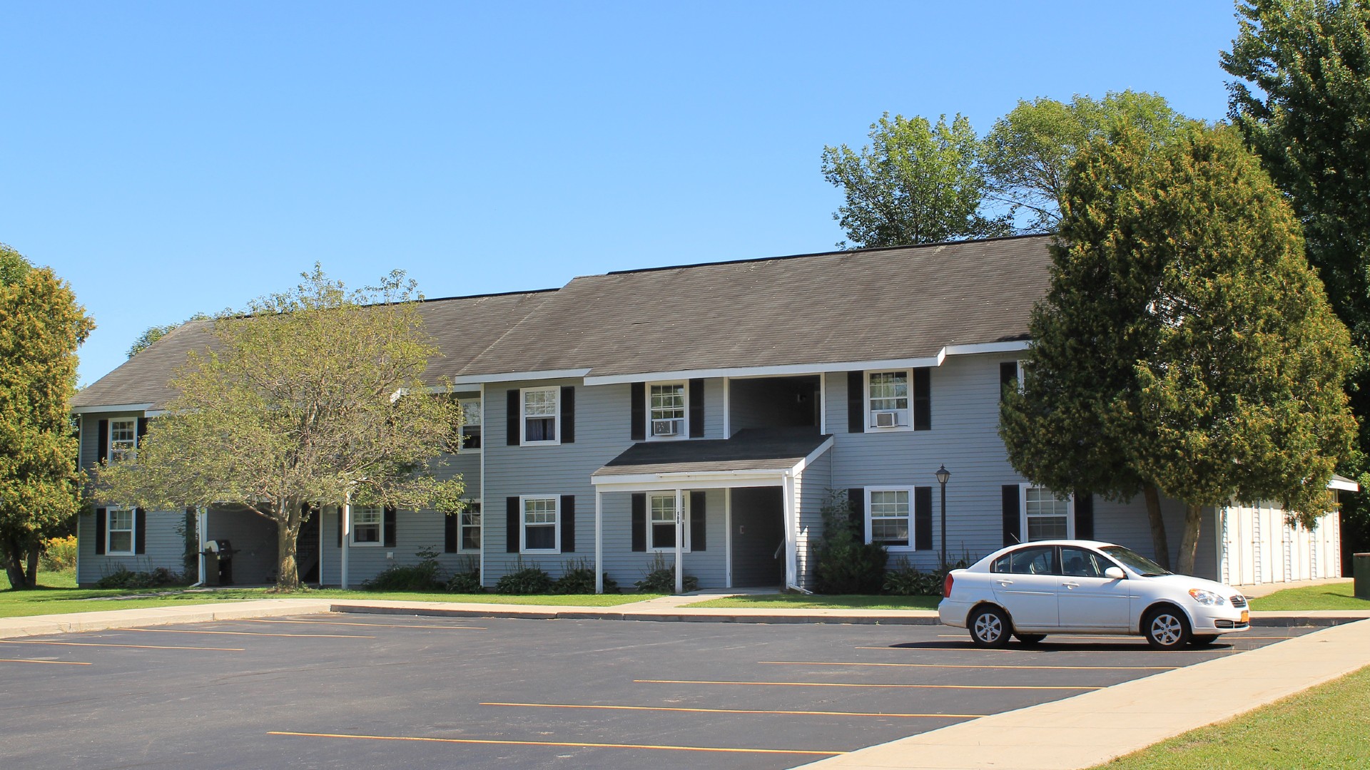 Apartments near Sackets Harbor NY street view of shipyard family apartments with parking lot for two plus four management