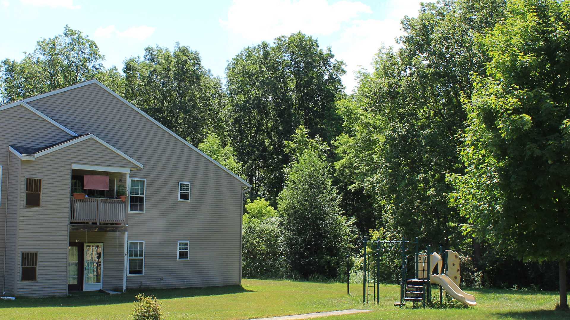 Senior Housing near Camillus NY image of connelly acres apartments backyard with playground from two plus four property management