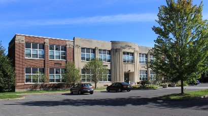 Senior Apartments near East Syracuse NY thumbnail image of heman street school apartments with parking from two plus four management